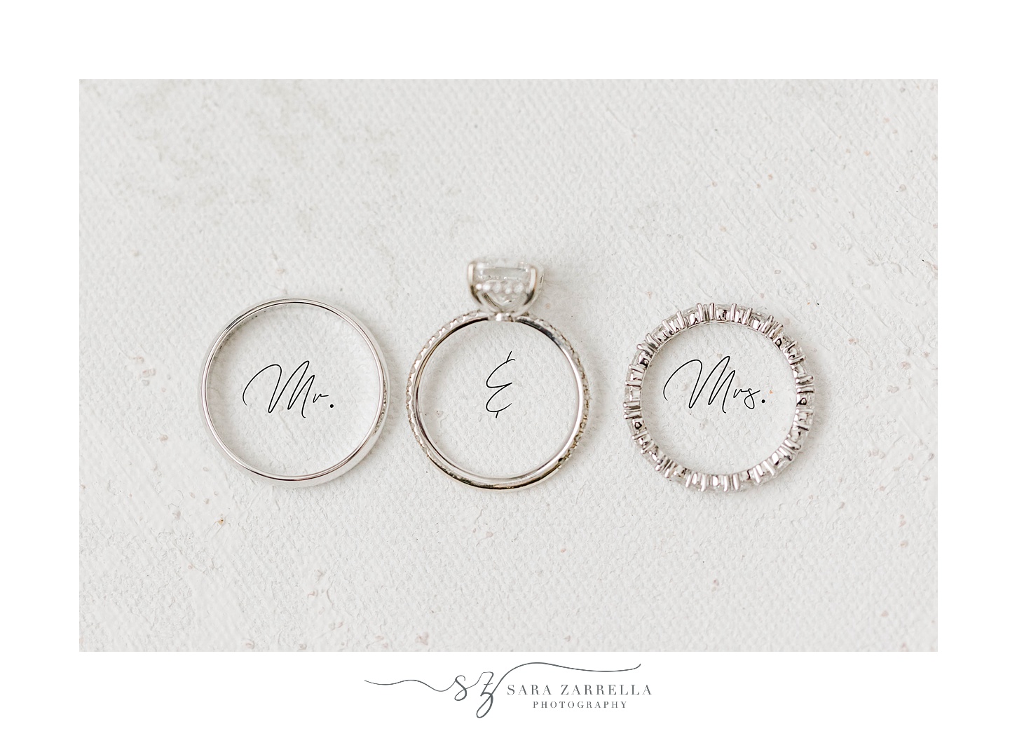 three wedding bands rest on Mr and Mrs script font 