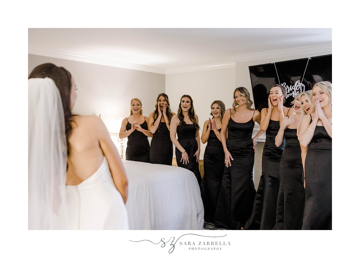 bridesmaids react to bride during first look in suite at Belle Mer