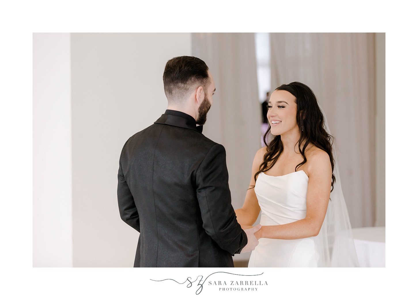 bride and groom hold hands smiling during first look at The Salon at Belle Mer