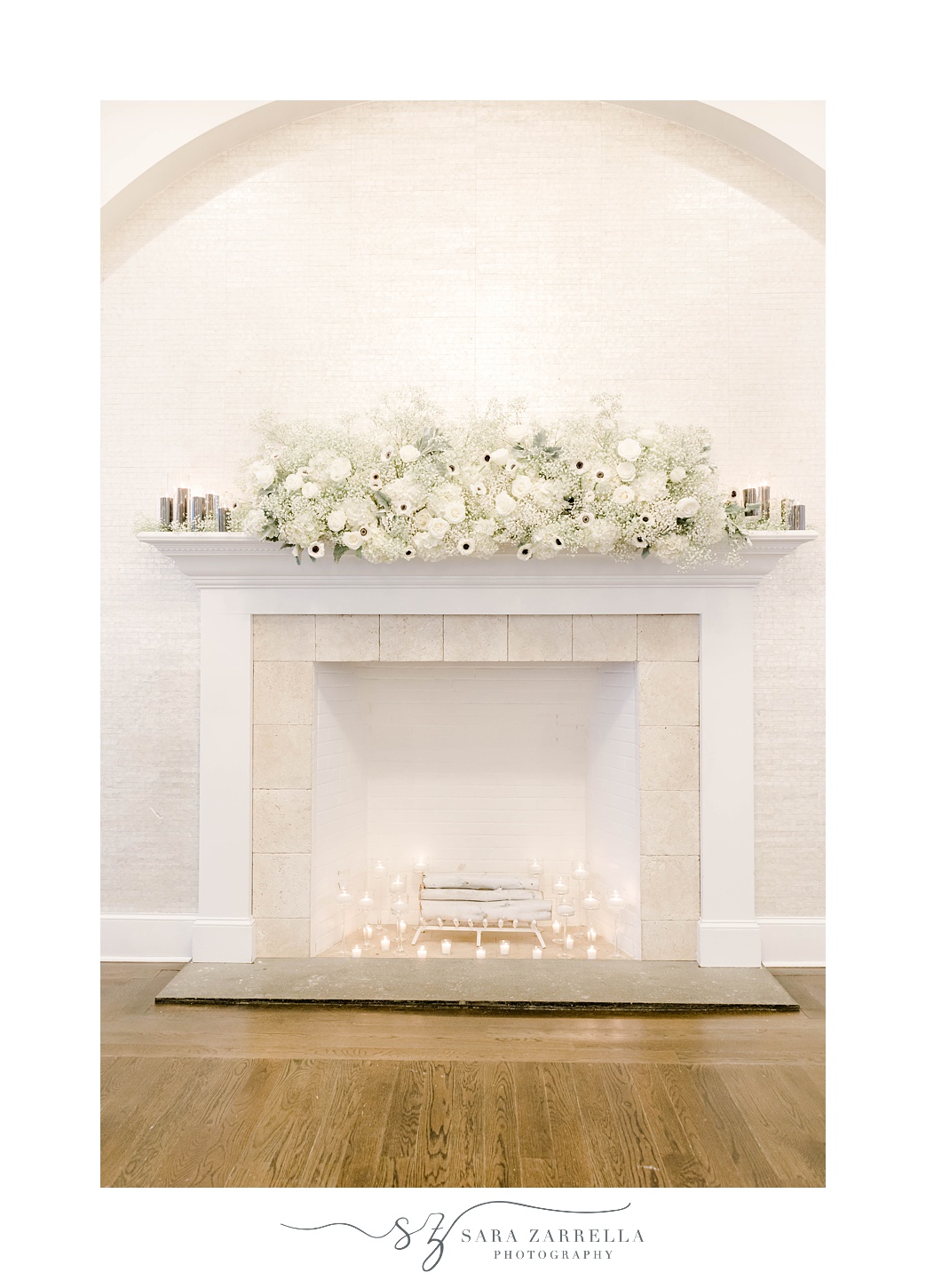 white flower arrangement rests on fireplace at The Salon at Belle Mer