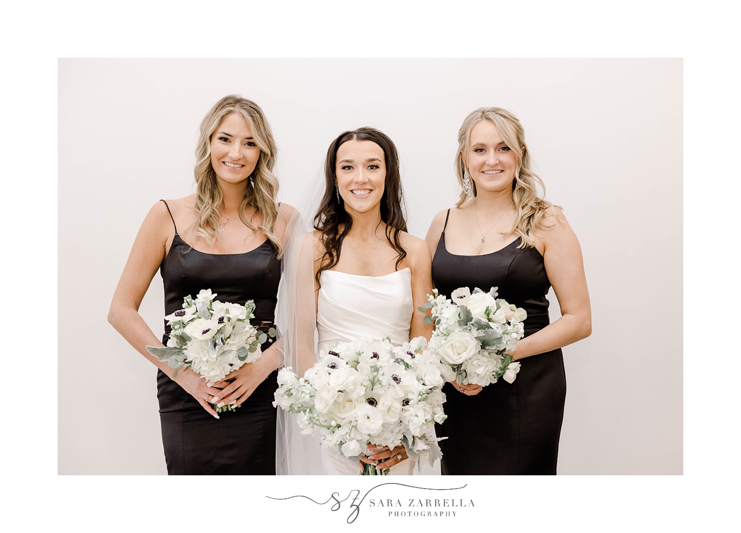 bride poses with bridesmaids in black gowns at The Salon at Belle Mer