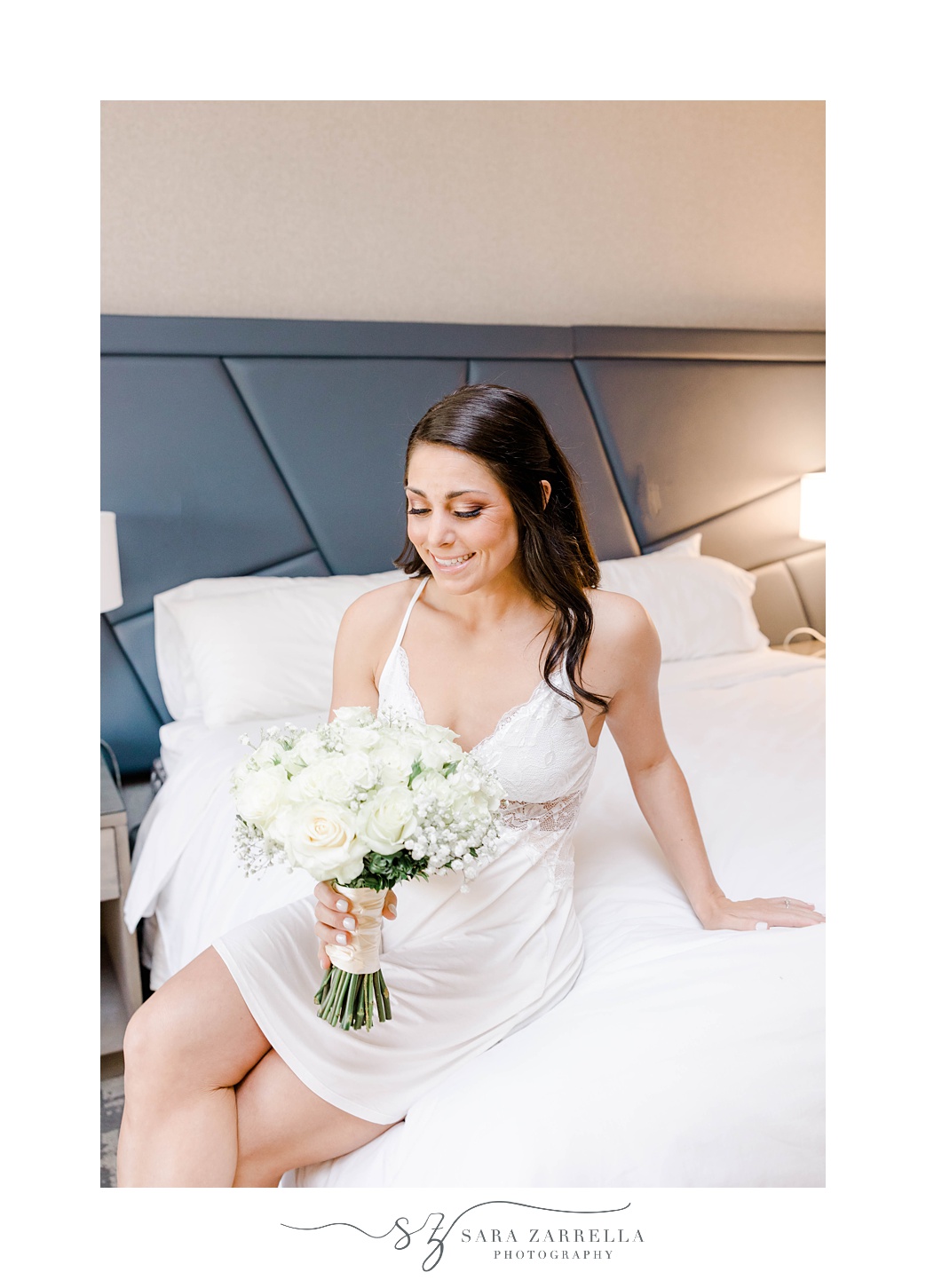 bride sits on bed in suite at Crowne Plaza in Warwick RI