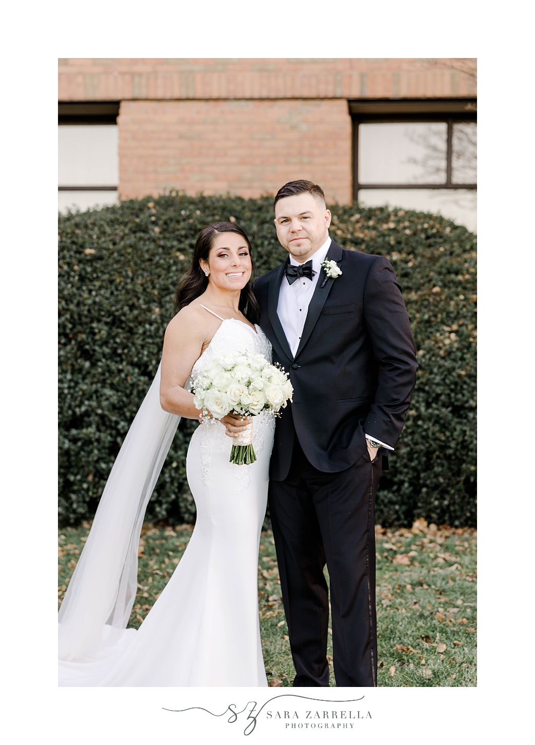 newlyweds pose standing side by side on lawn at the Crowne Plaza Warwick