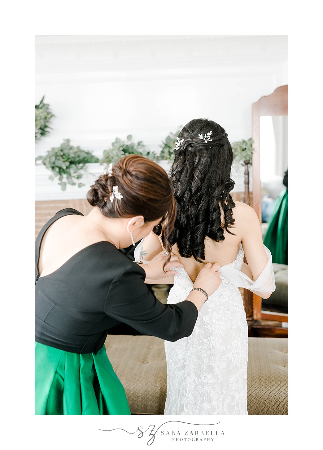 mom helps bride into wedding dress at OceanCliff Hotel bridal suite 