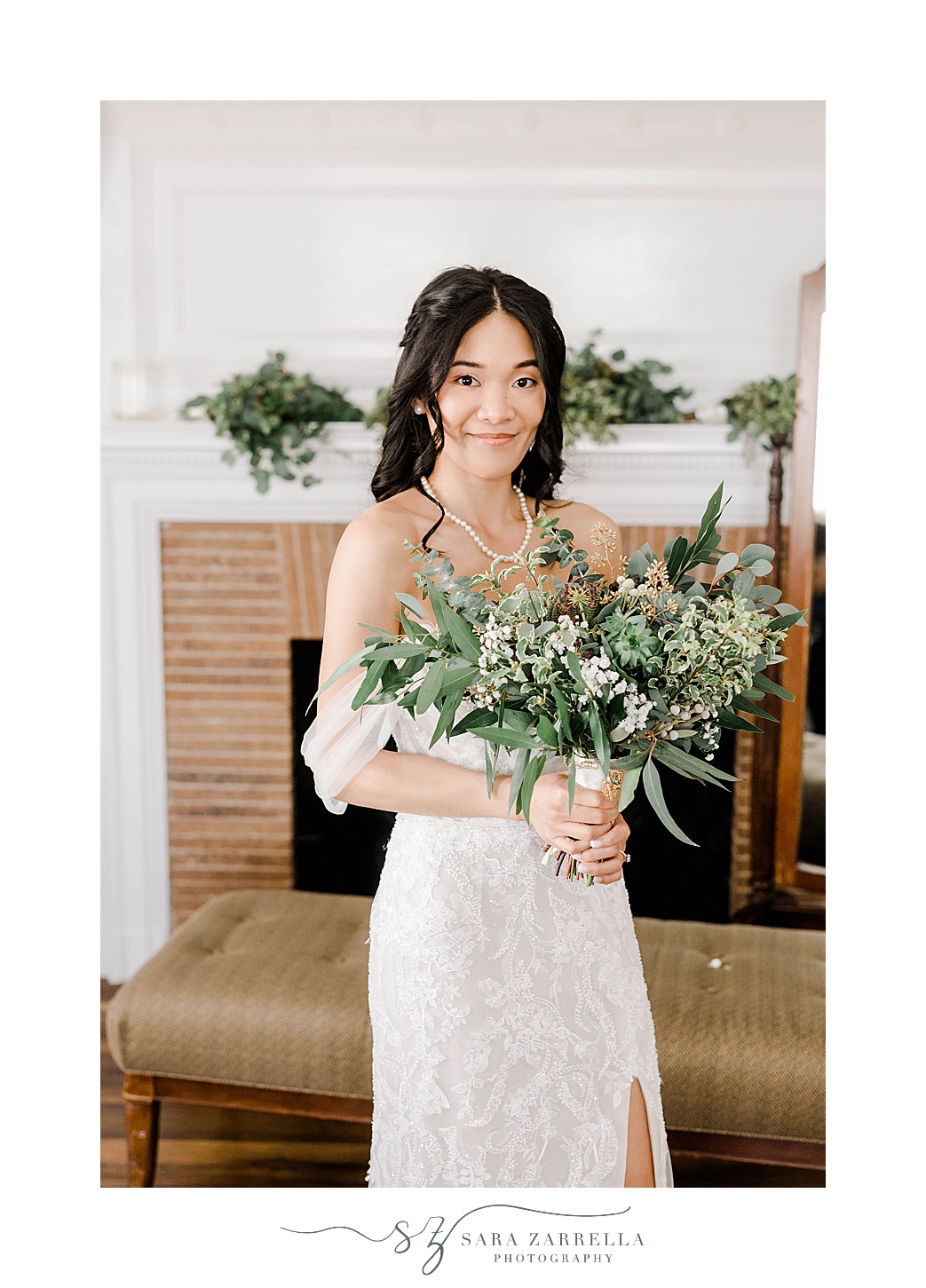 bride holds bouquet of greenery and succulents inside suite at OceanCliff Hotel