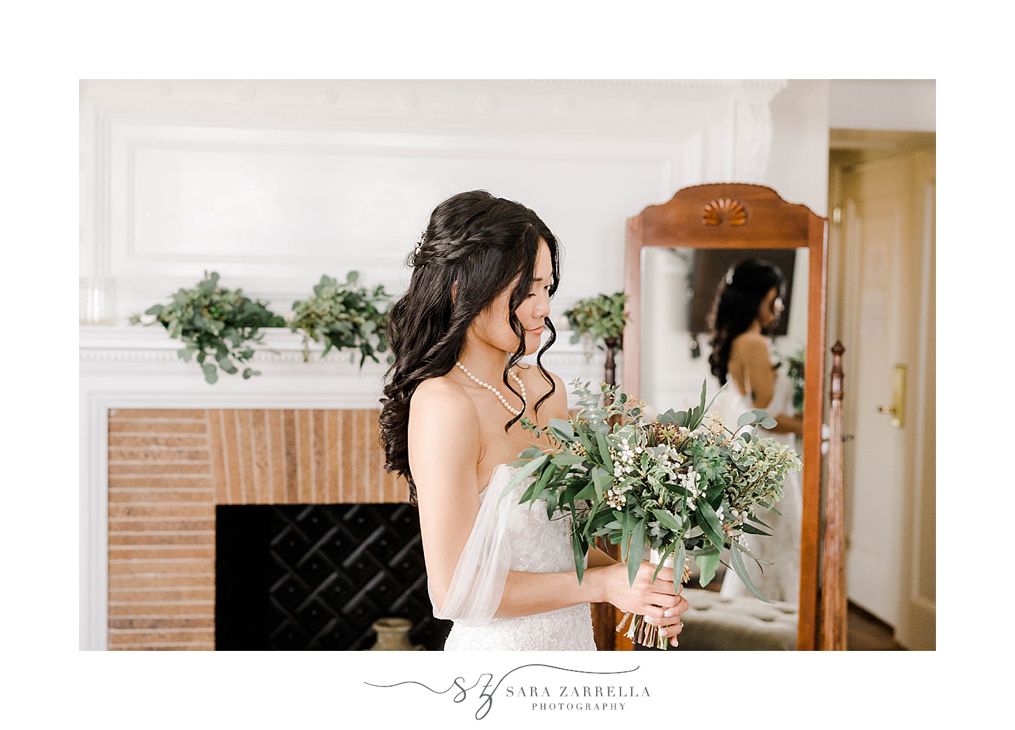 bride looks down at bouquet of greenery and succulents in suite at OceanCliff Hotel