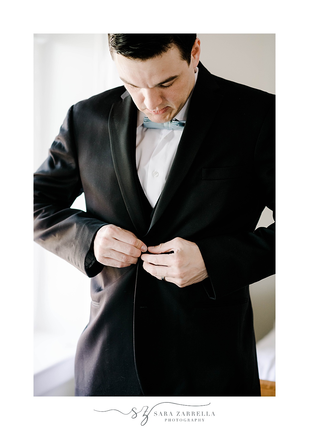 groom in blue bow tie buttons up black jacket 