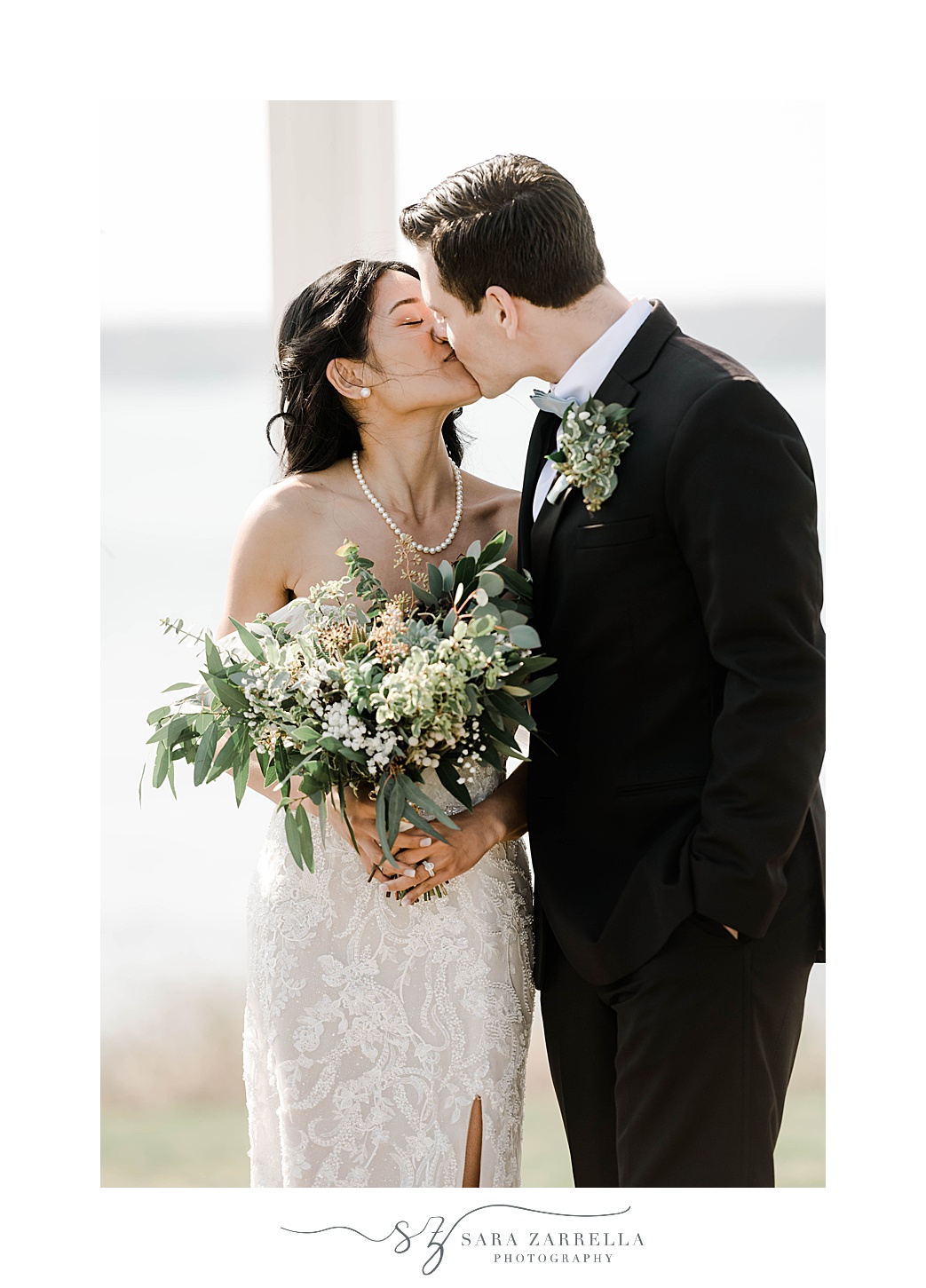 bride and groom kiss while she holds bouquet of succulents 