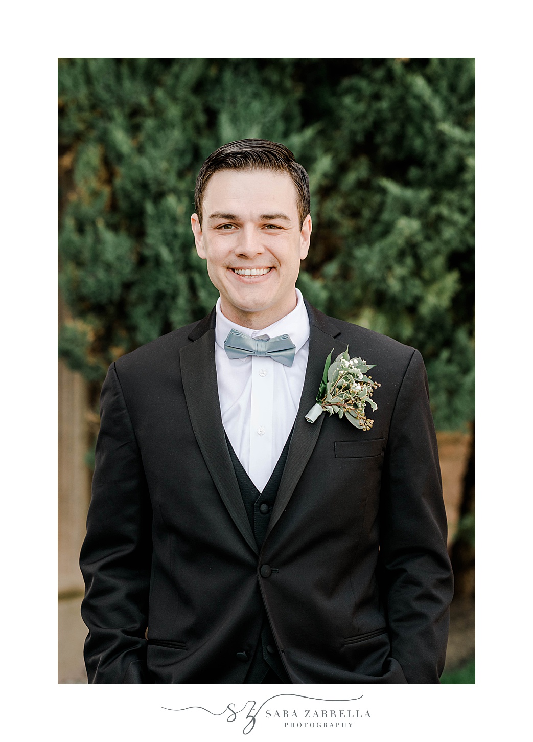 groom smiles in black jacket with blue tie and succulent boutonnière 