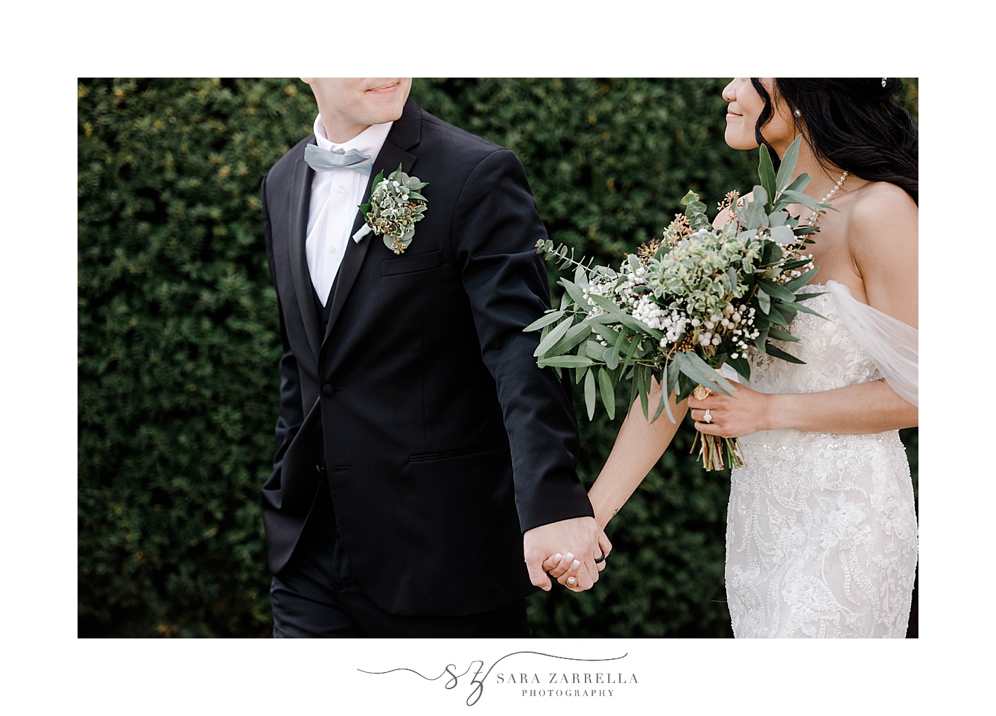 groom in black suit holds bride's hand while she carries succulent bouquet 