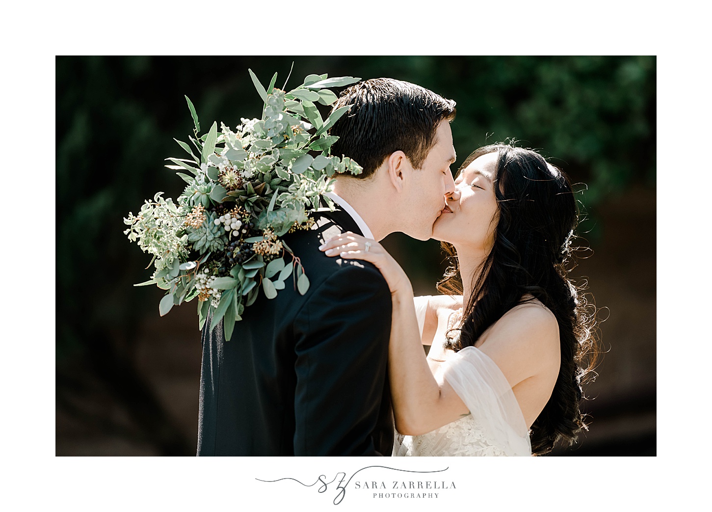 bride and groom kiss with succulent bouquet resting on his shoulders 