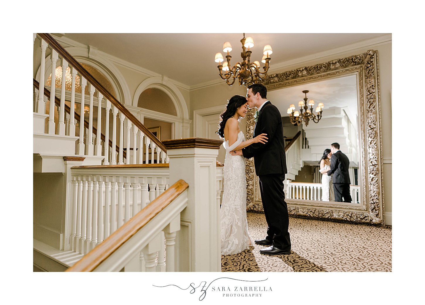 groom kisses bride's forehead near staircase at OceanCliff Hotel