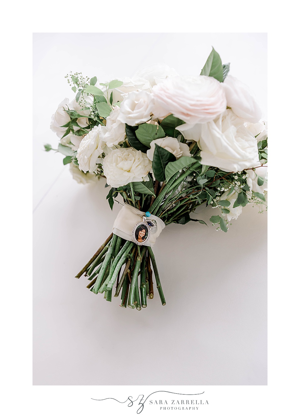 bride's bouquet of pale pink roses and ivory roses with charm around bouquet 