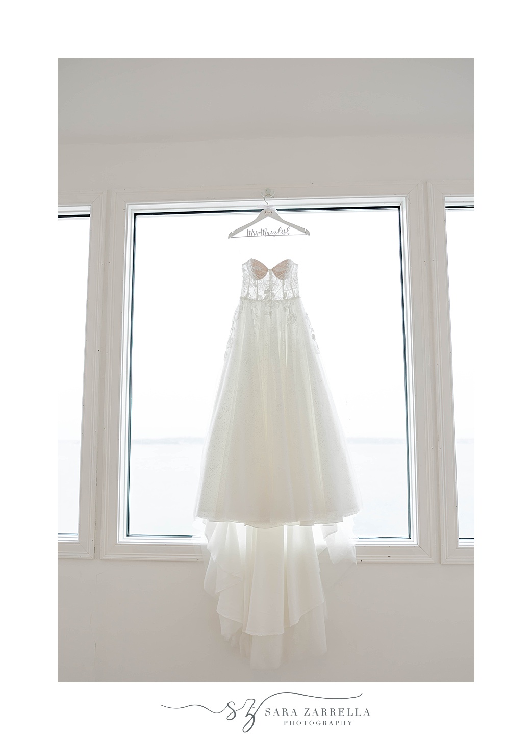 wedding dress hangs in window in suite at Belle Mer Island House