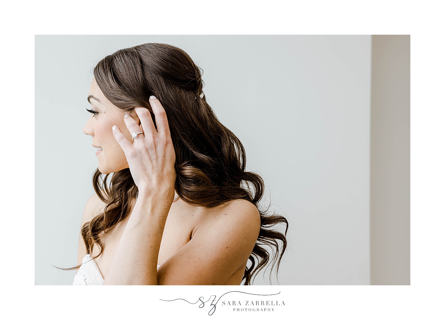 bride brushes hair over ear before wedding day