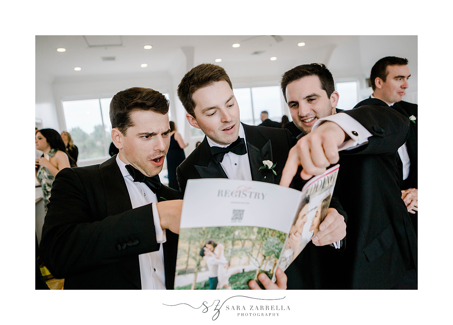 groomsmen look at welcome magazine for RI wedding