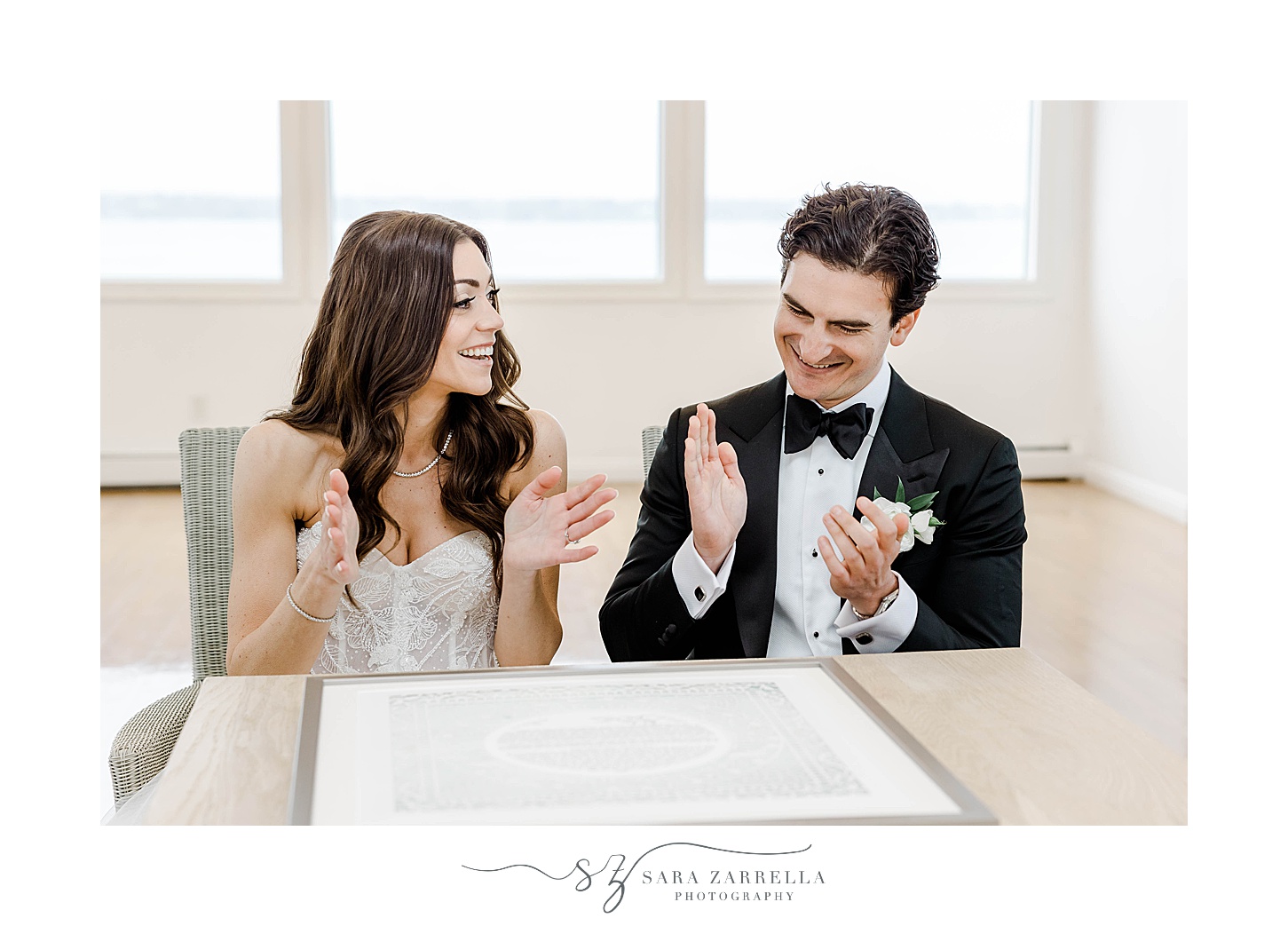 bride and groom clap during Ketubah signing at Belle Mer Island House