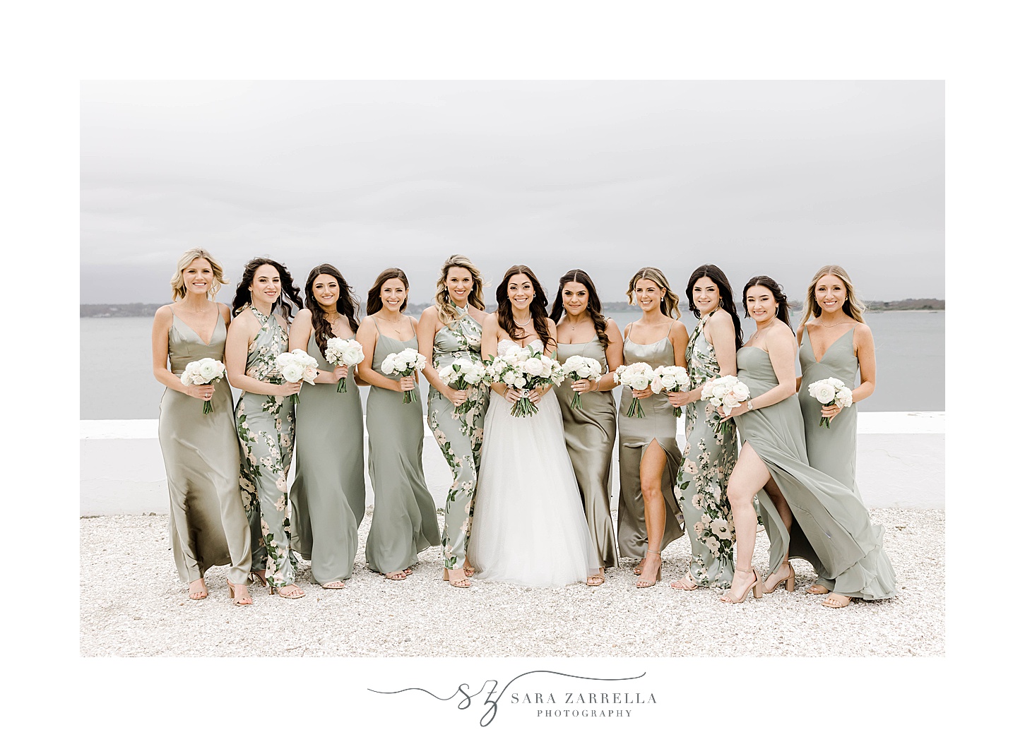 bride stands on beach with bridesmaids in mismatched gowns at Belle Mer Island House