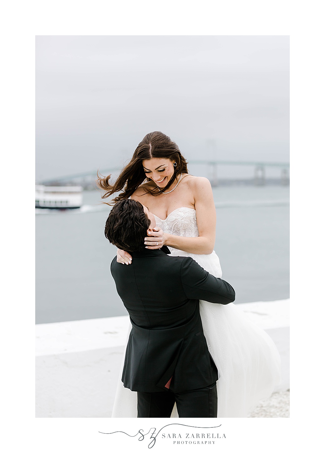 bride looks down at groom in front of Narragansett Bay 