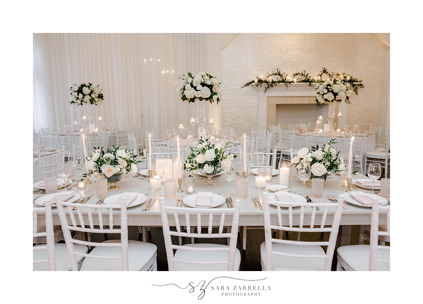 wedding reception with white and green flowers down table with pillar candles 