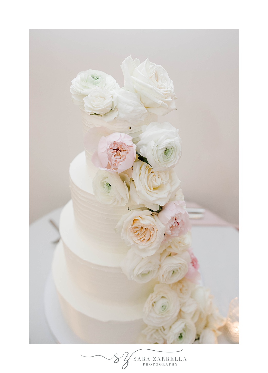 tiered wedding cake with pink and white flowers at Belle Mer Island House