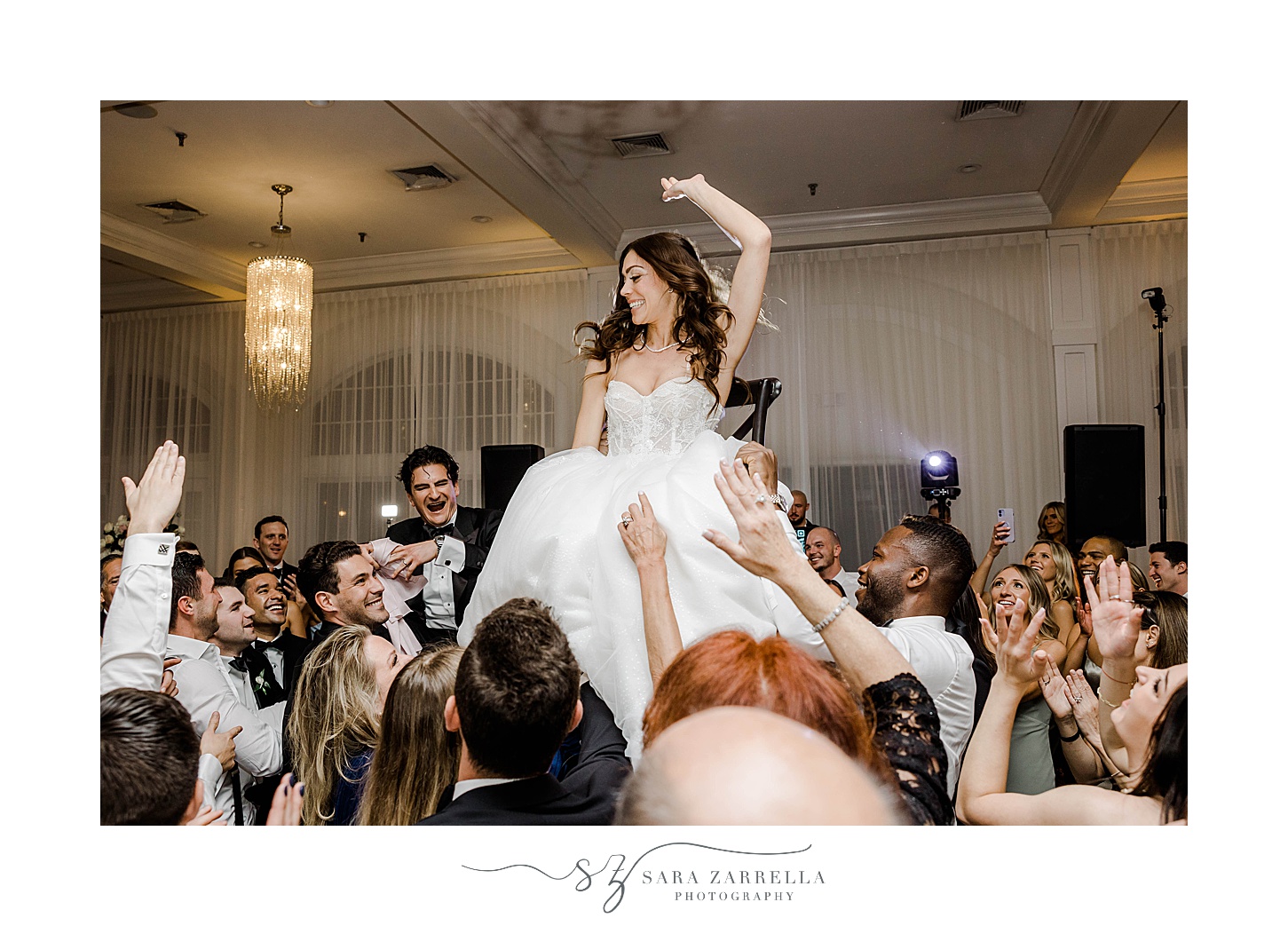 guests lift up bride during horah dance 