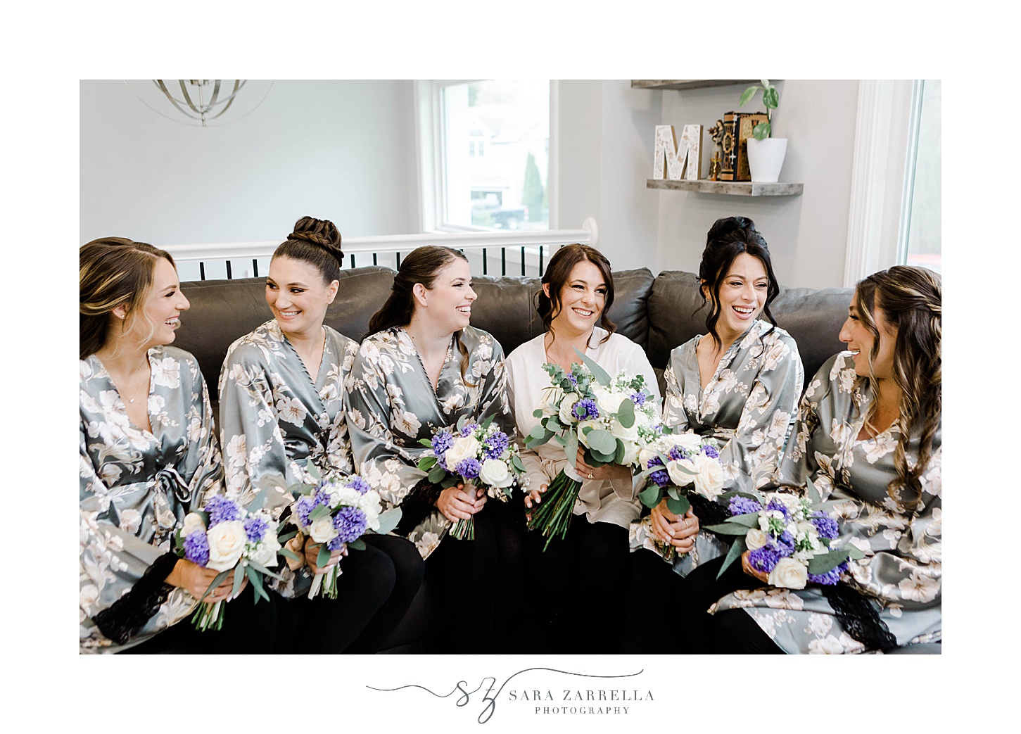 bride sits with bridesmaids in matching robes