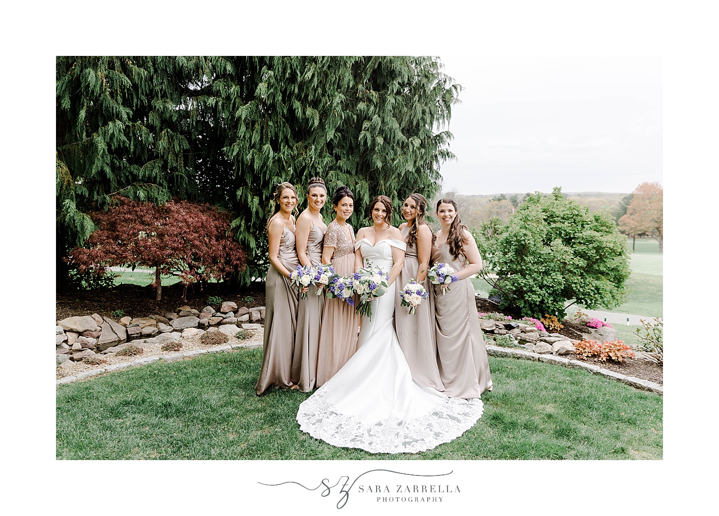 bride poses with bridesmaids in blush gowns