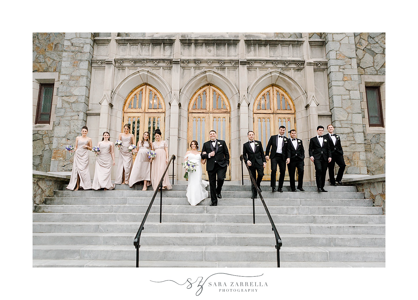 bride and groom pose with wedding party in pink and black on steps of Our Lady of the Rosary