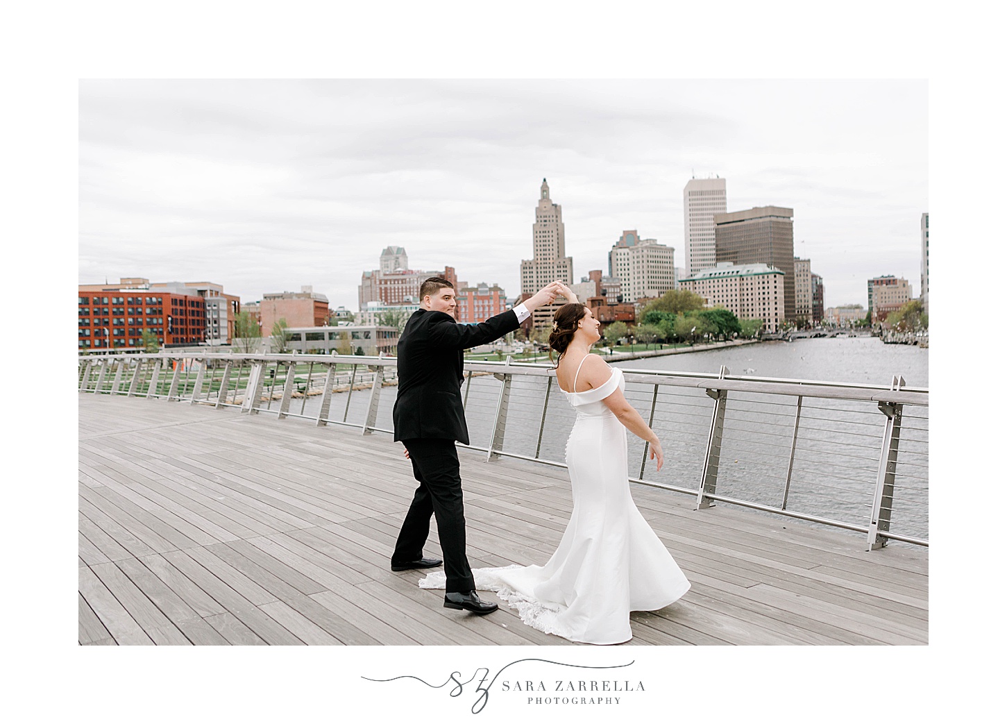 groom twirls bride on Providence Pedestrian Bridge