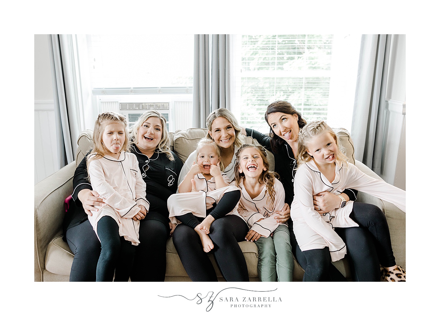 bride laughs with bridesmaids and flower girls in matching pajamas in suite at OceanCliff Hotel
