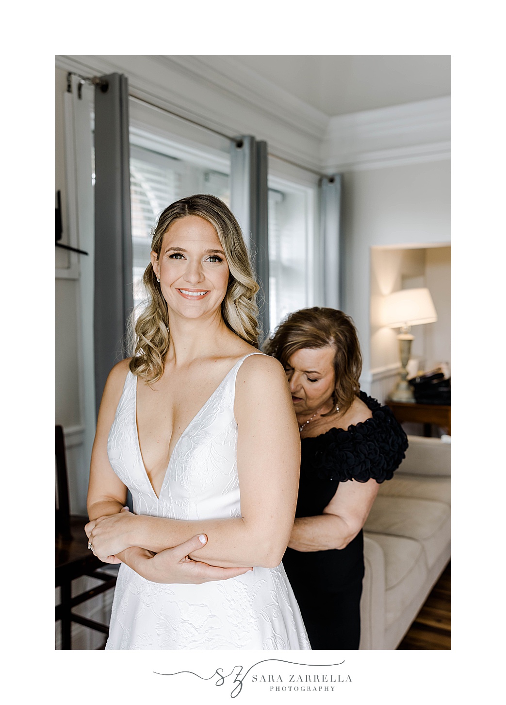 mother helps bride into wedding dress before OceanCliff Hotel wedding day