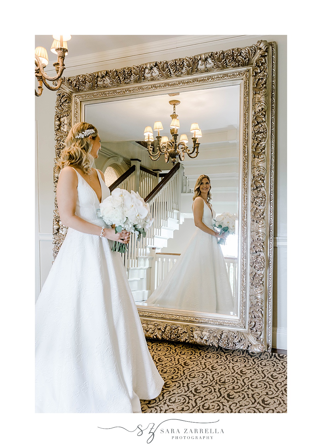 bride looks in floor length mirror with gold frame at OceanCliff Hotel