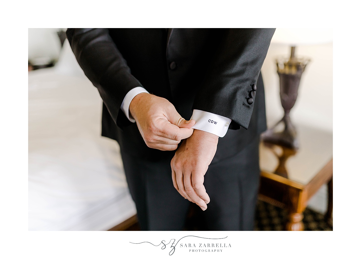 groom adjusts custom cufflinks and cuffs before OceanCliff Hotel wedding
