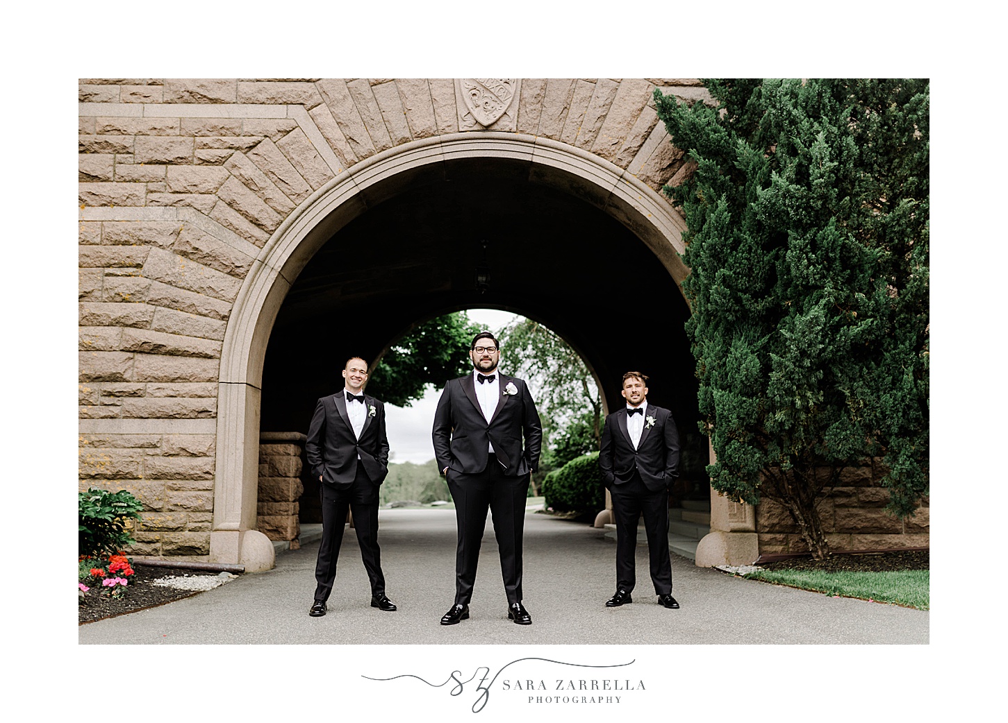 groom stands with groomsmen in black suits at OceanCliff Hotel