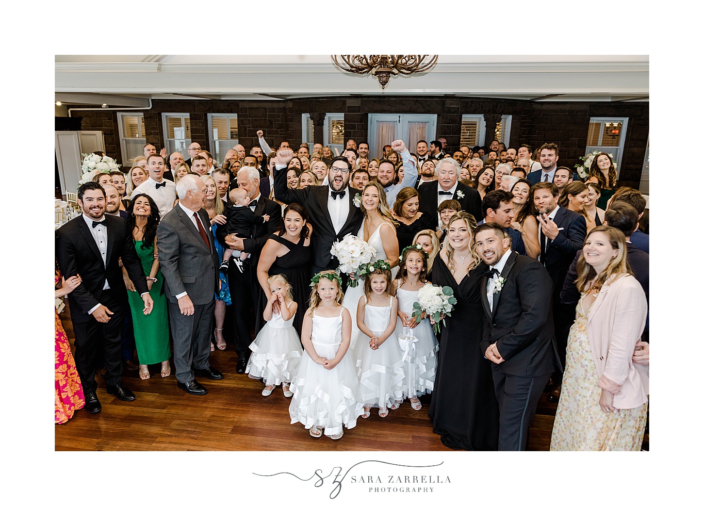 newlyweds pose with wedding guests on dance floor at spring OceanCliff Hotel wedding 
