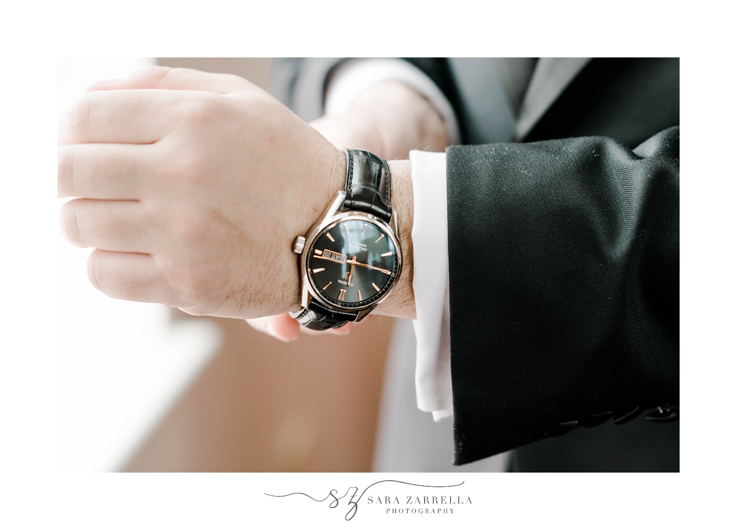 groom adjusts new watch on wrist during prep for wedding at the Omni Providence Hotel