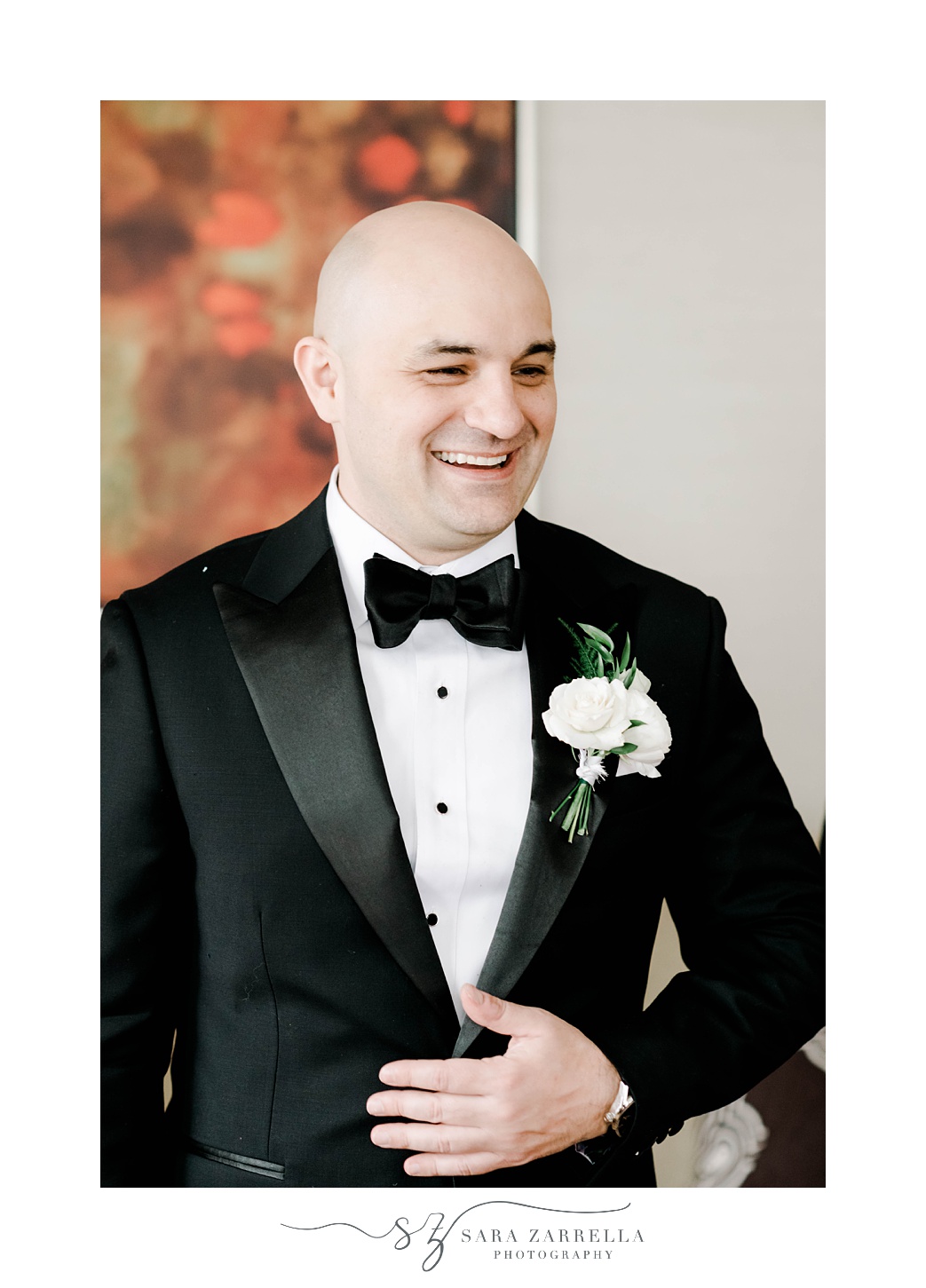groom in classic black tux laughs at the Omni Providence Hotel