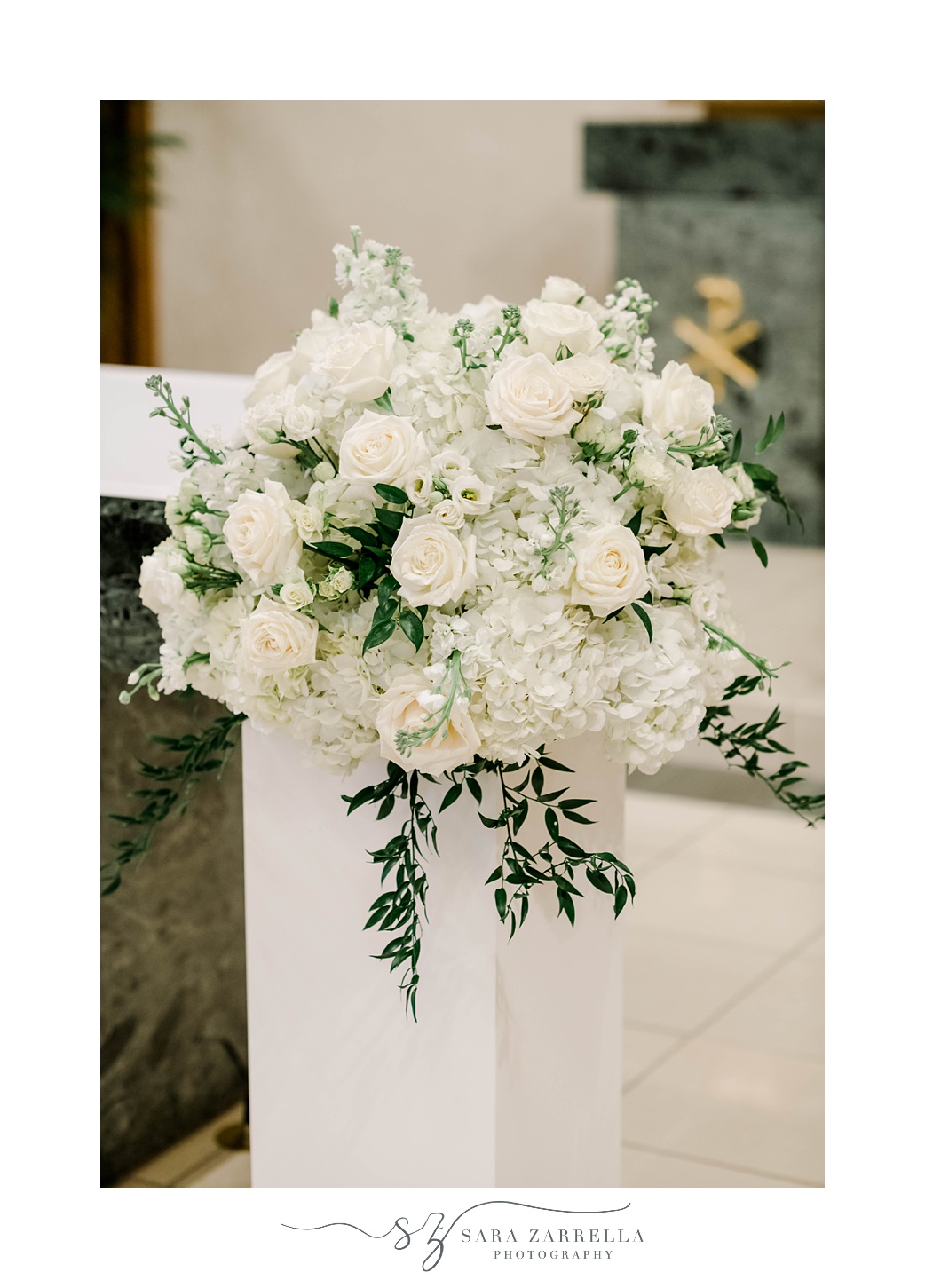 floral arrangement of white flowers and green leaves in church 