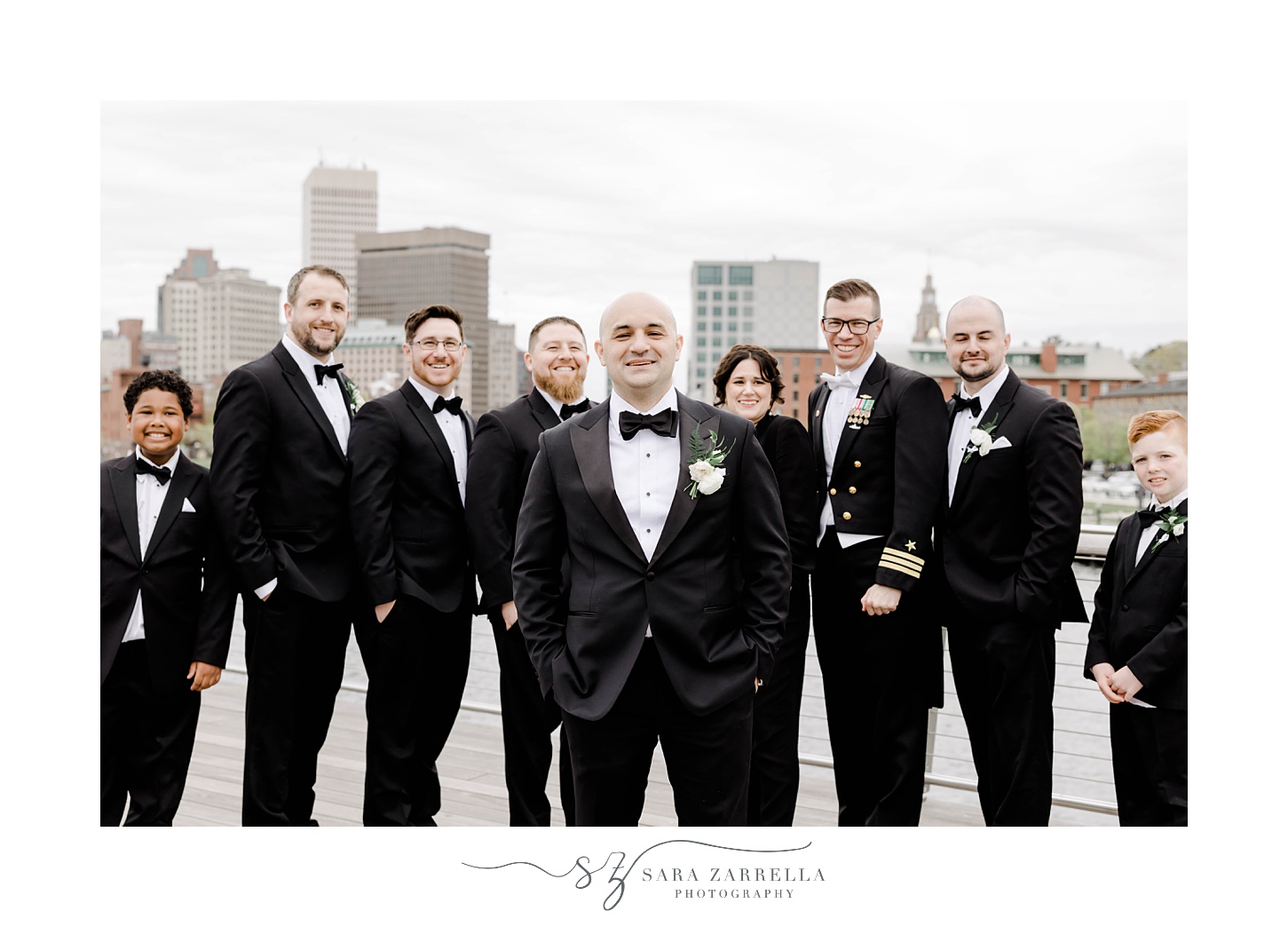 groom stands with groomsmen and best woman on Providence pedestrian bridge