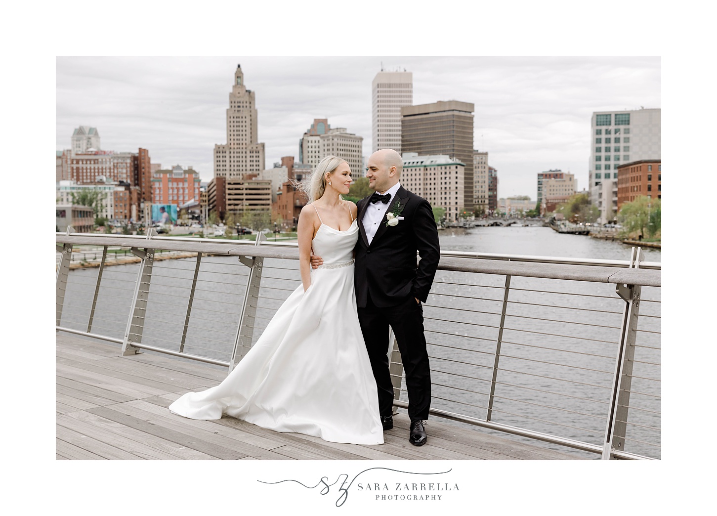 newlyweds hug on Providence pedestrian bridge