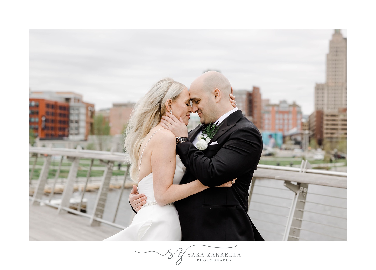 bride and groom lean into each other on the Providence pedestrian bridge