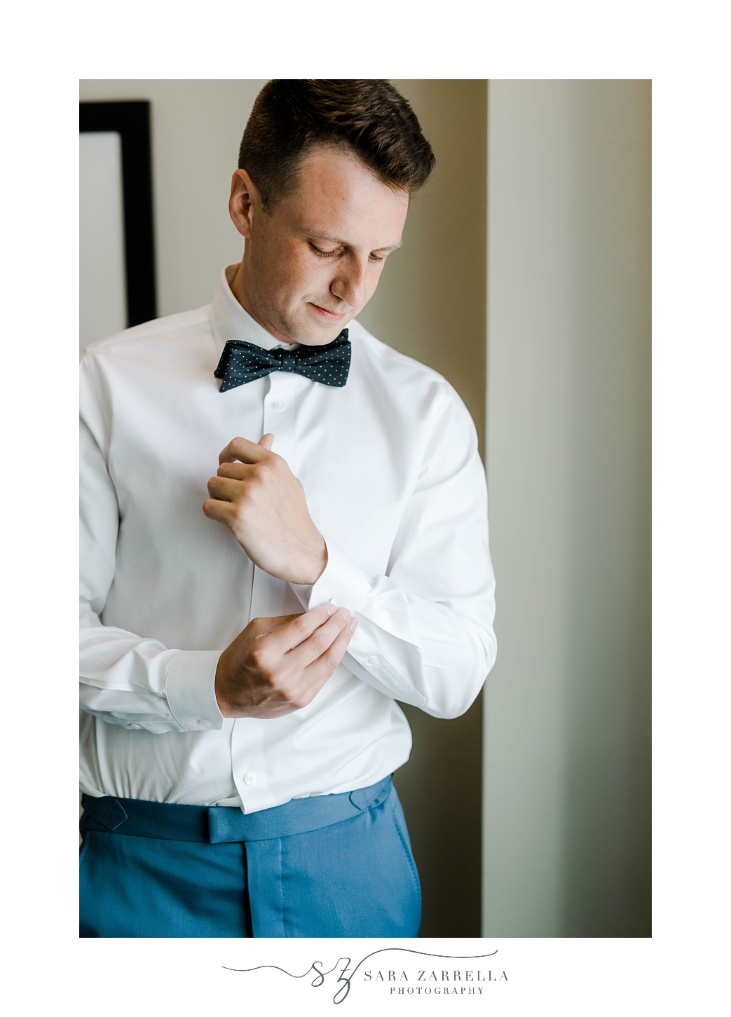 groom adjusts cufflinks before Newport Beach House wedding