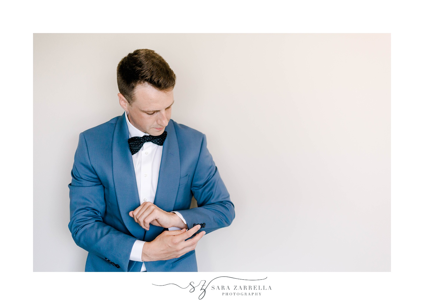 groom adjusts cufflinks before elegant Newport Beach House wedding