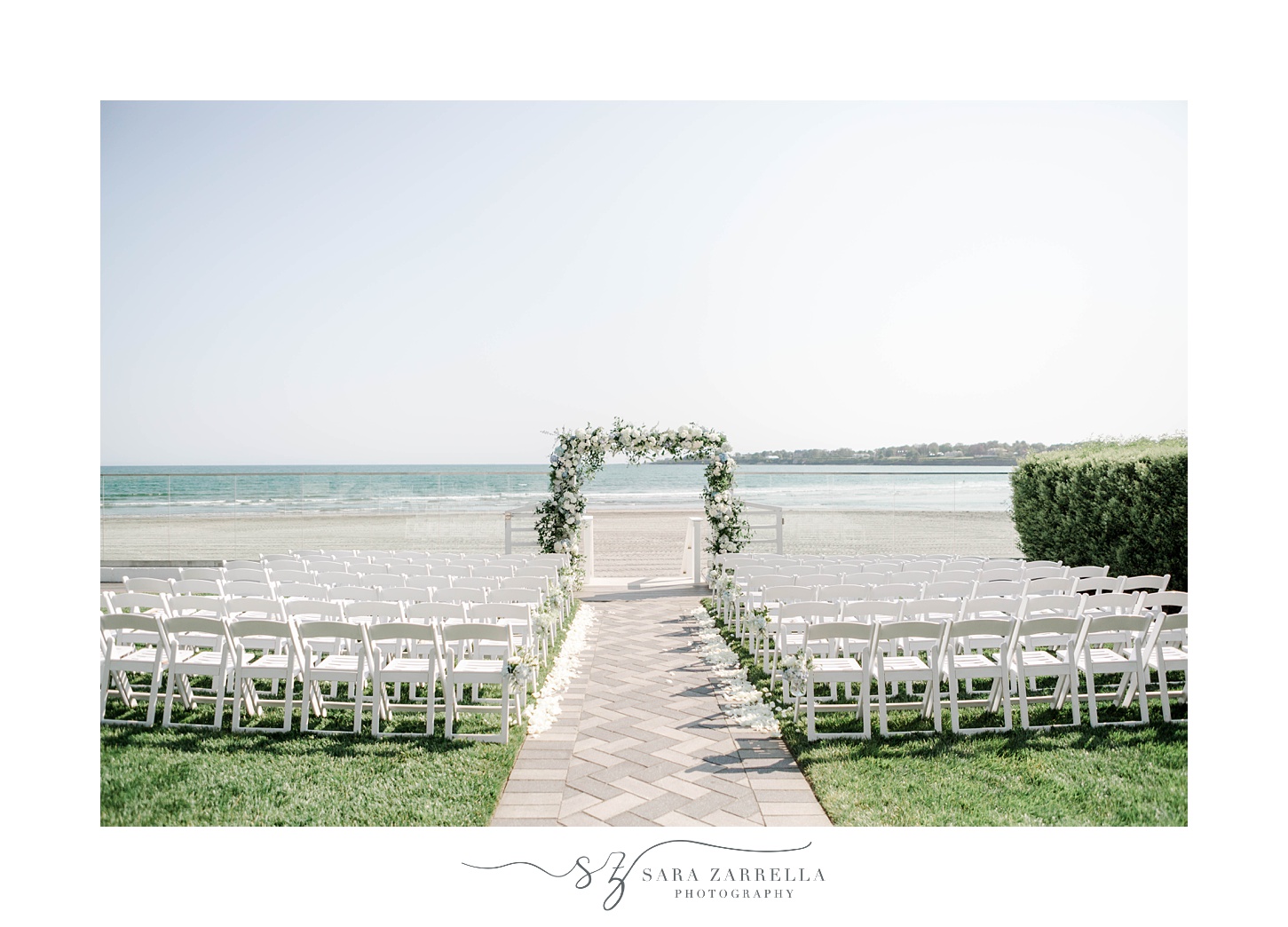 elegant Newport Beach House wedding ceremony site with arbor of white flowers