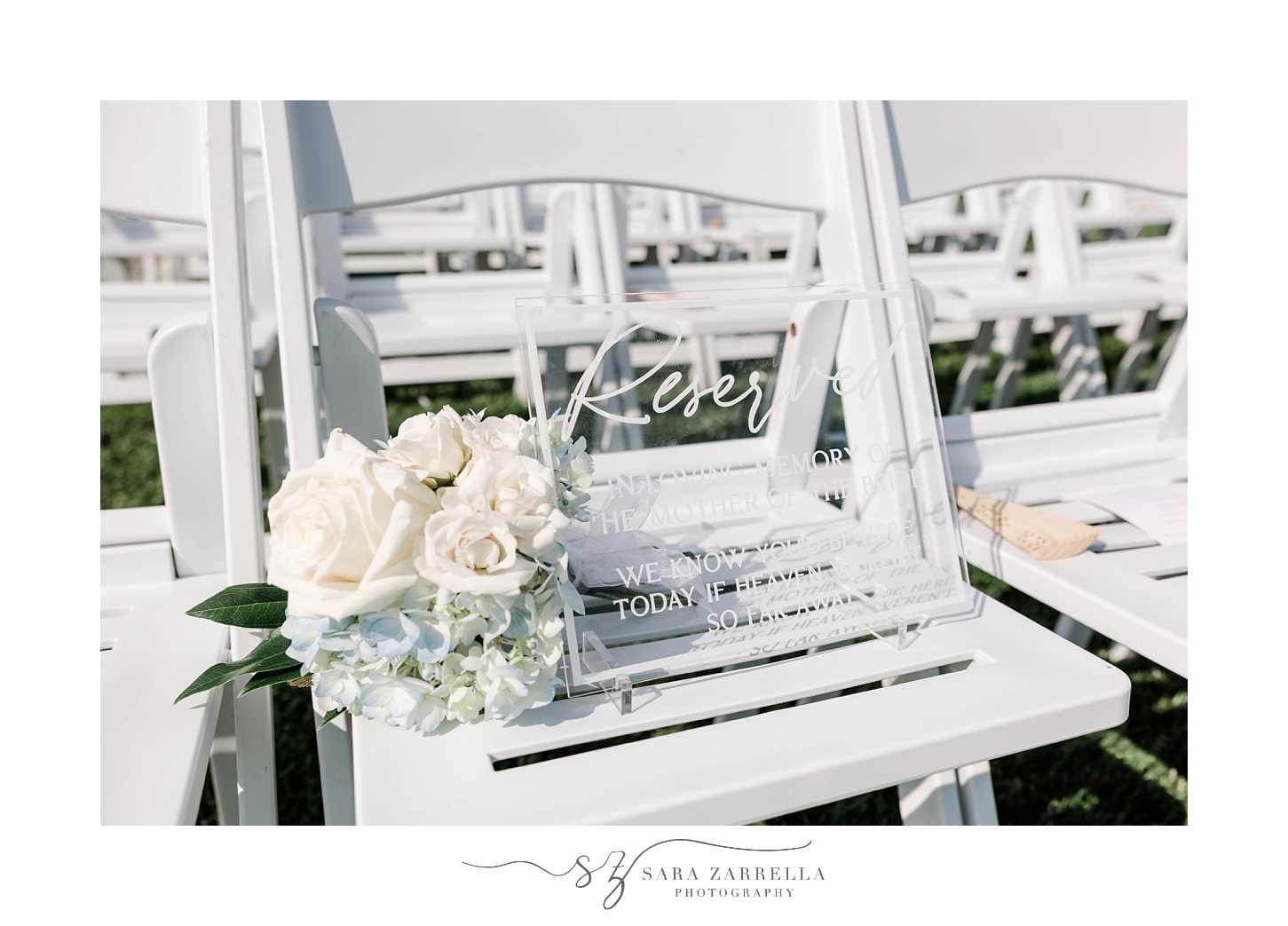 reserved sign on white chair with bouquet of ivory roses