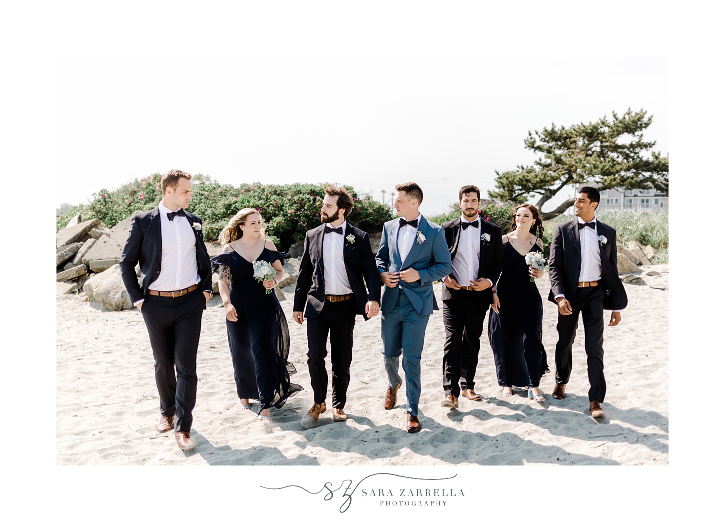 groom walks with groomsmen and bridesmaids on Newport Beach