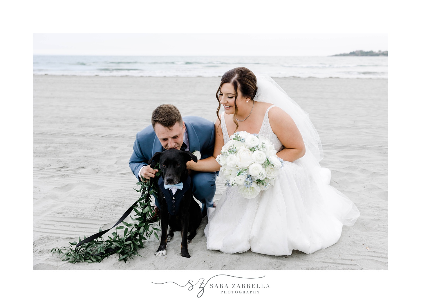 newlyweds hug black lap puppy on Newport Beach