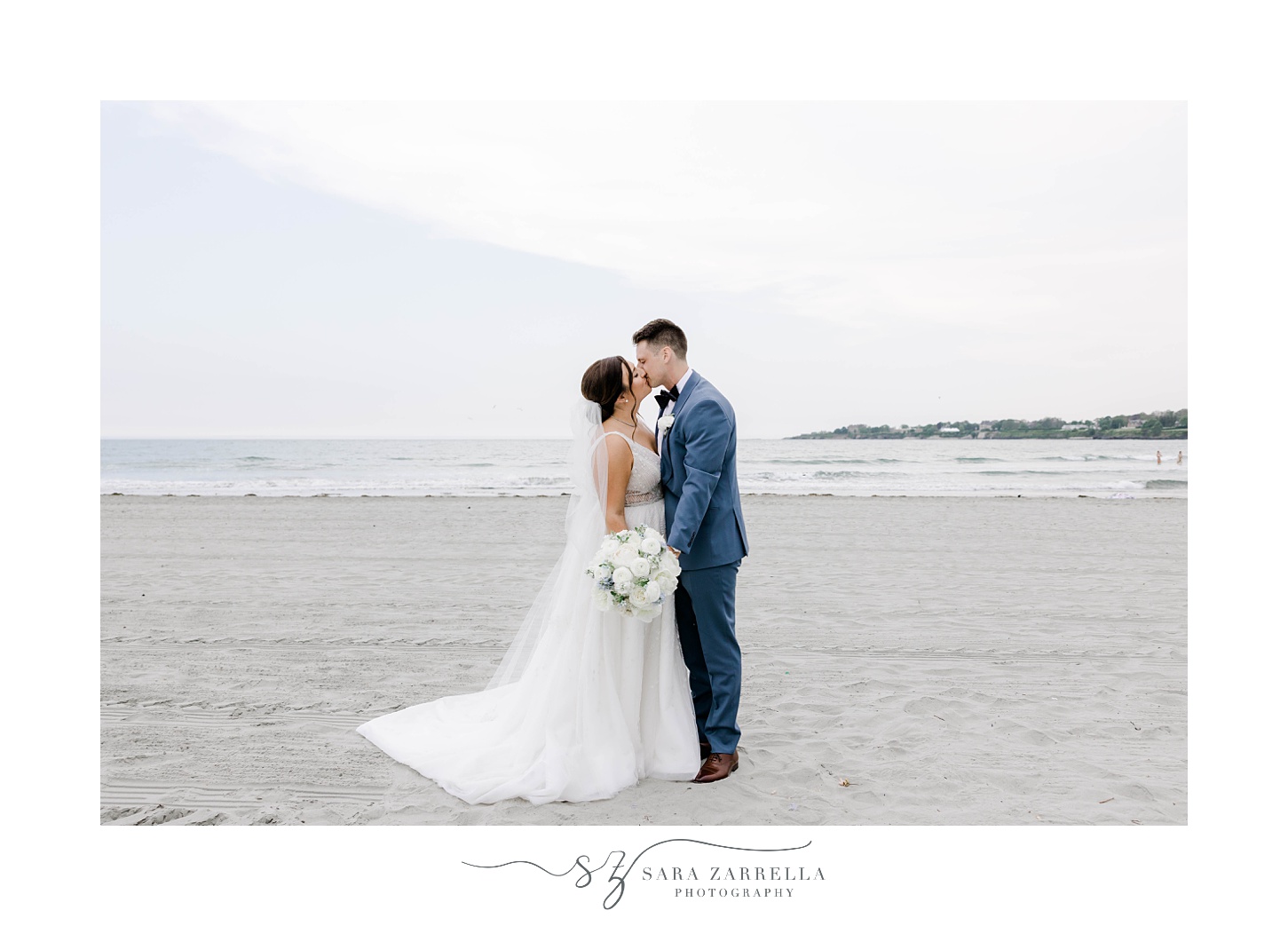 bride and groom kiss standing on Newport Beach