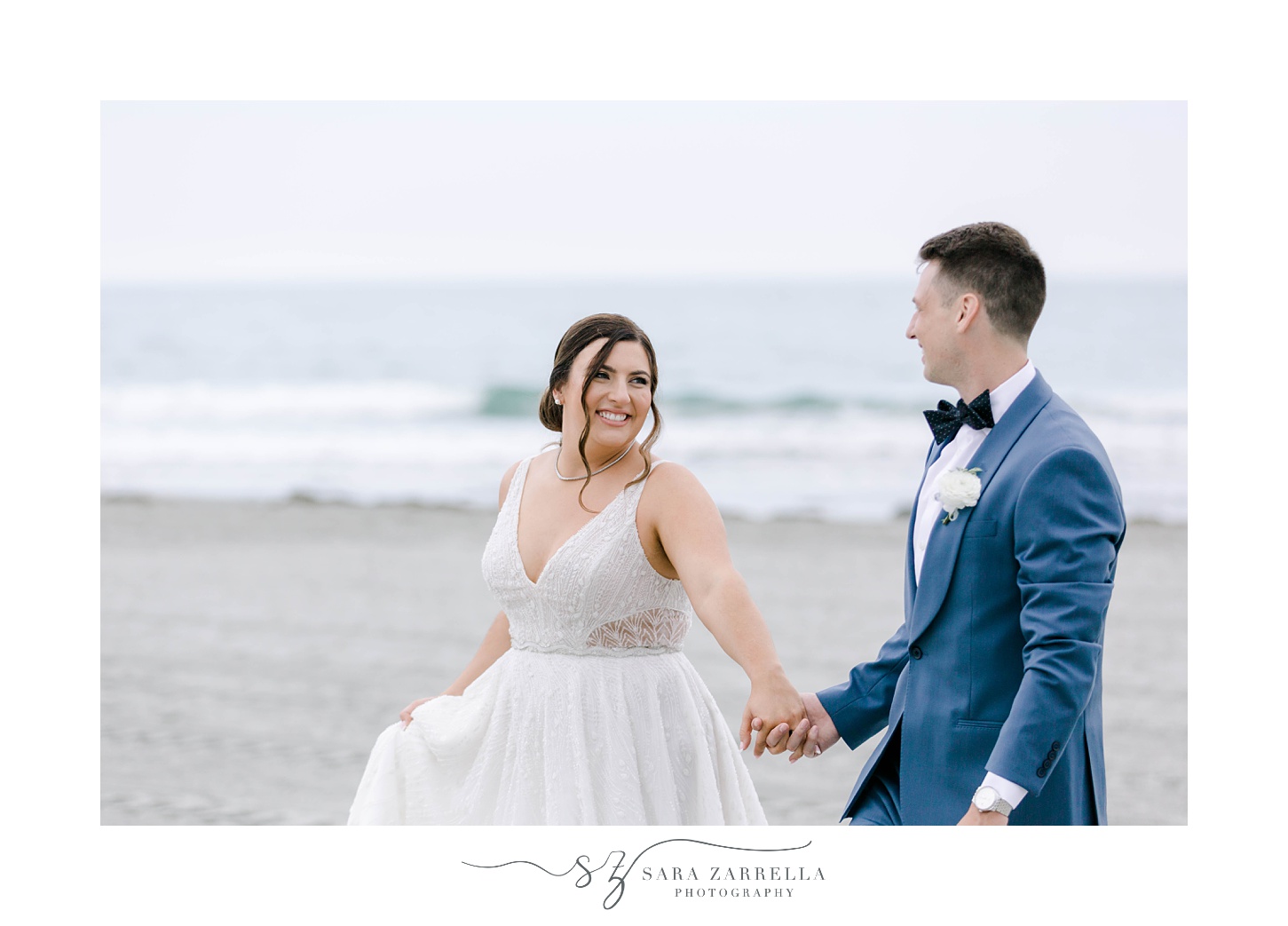 bride and groom hold hands walking along Newport Beach